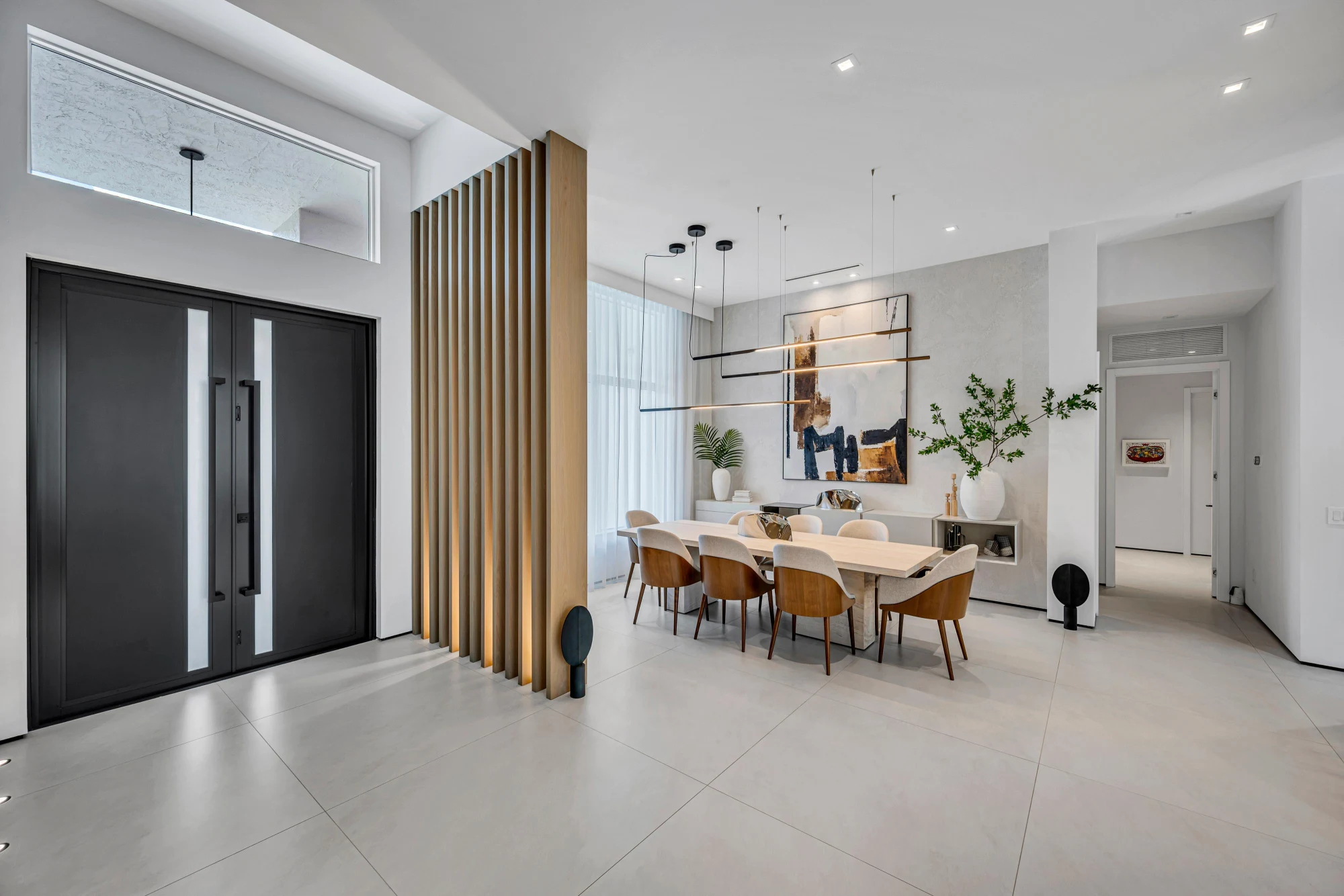 Entry foyer with a white oak slat screen and black double doors in the Long Lake Ranches estate, Davie, Florida, designed by Luxe Design Studios