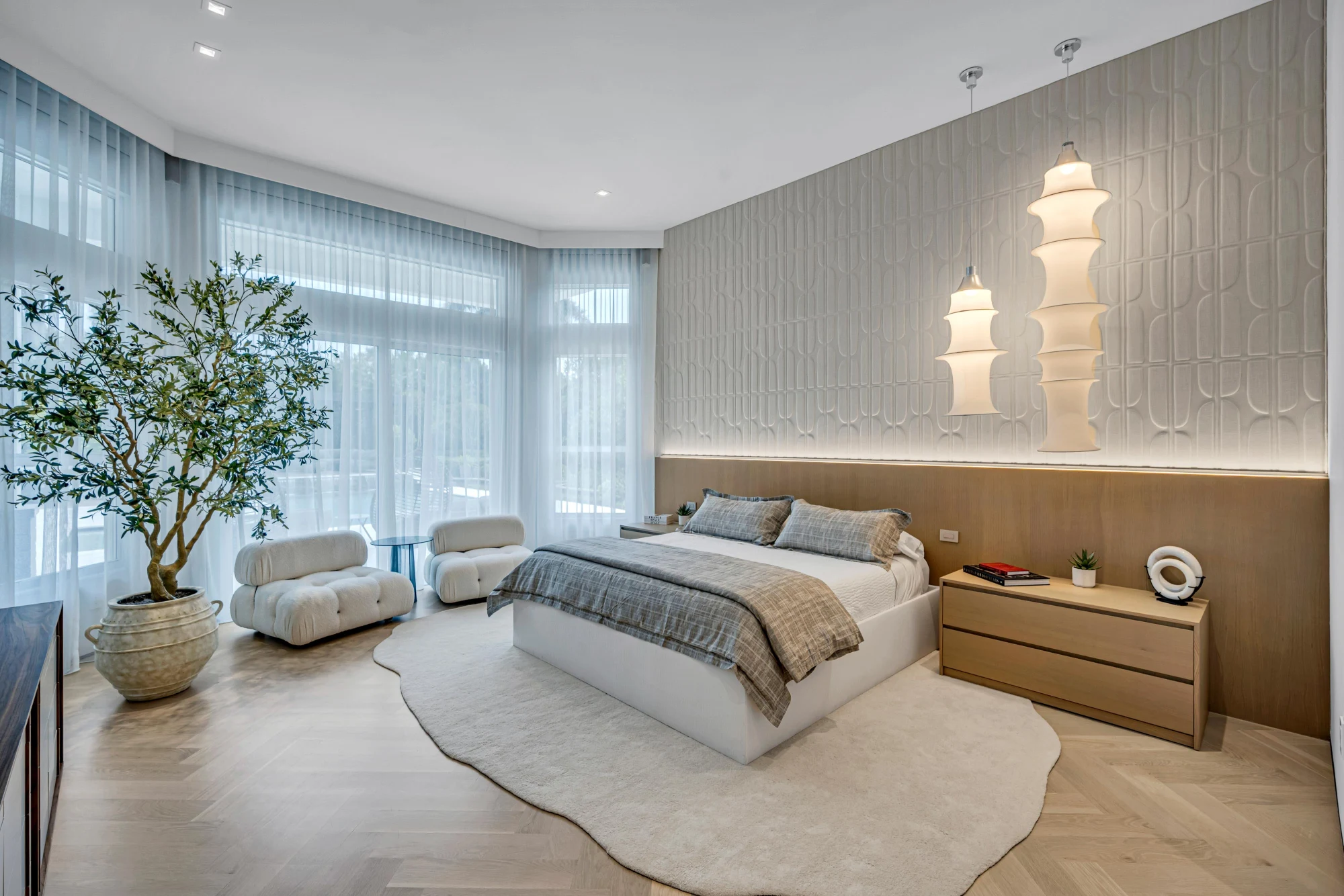 Primary bedroom with a sculpted relief wall and backlit oak headboard in the Long Lake Ranches estate, Davie, Florida, designed by Luxe Design Studios