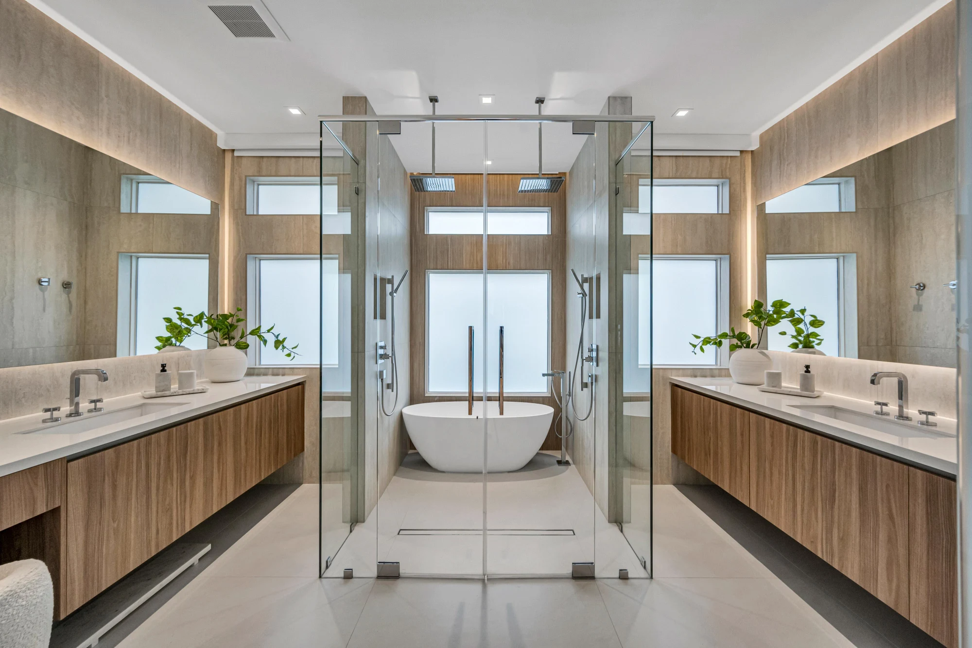 Primary bathroom with twin floating vanities and a glass wet room in the Long Lake Ranches estate, Davie, Florida, designed by Luxe Design Studios