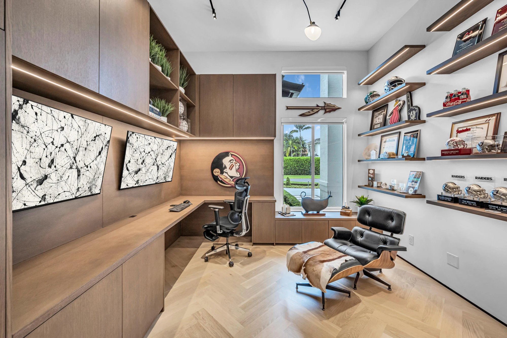 Home office lined in walnut millwork with a built-in desk and lit shelving in the Long Lake Ranches estate, Davie, Florida, designed by Luxe Design Studios